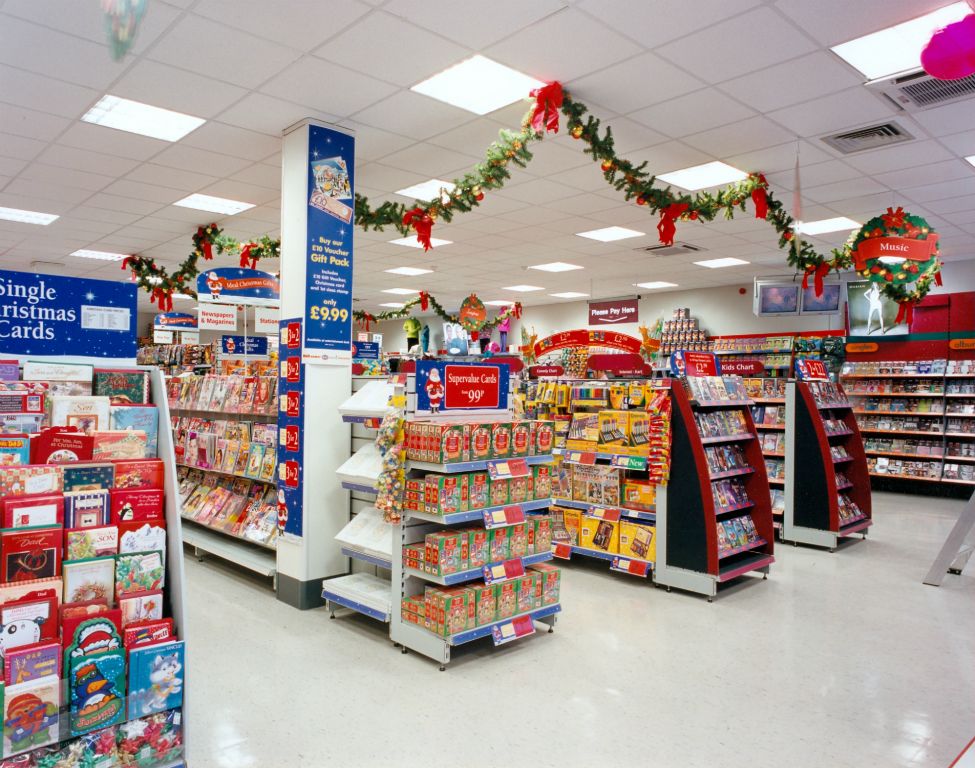 Magazines and Christmas Stationery displays in Downham, with Entertainment in the background