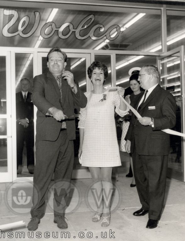 Katie and Phillip from the popular sixties OXO advertisements (Mary Holland and Richard Clarke) cut the ribbon with a flourish to launch the huge Woolco Department Store. Mr G.T. Cooke, the DIvision's Advertising Manager appears relieved and delighted with the stars' showmanship.