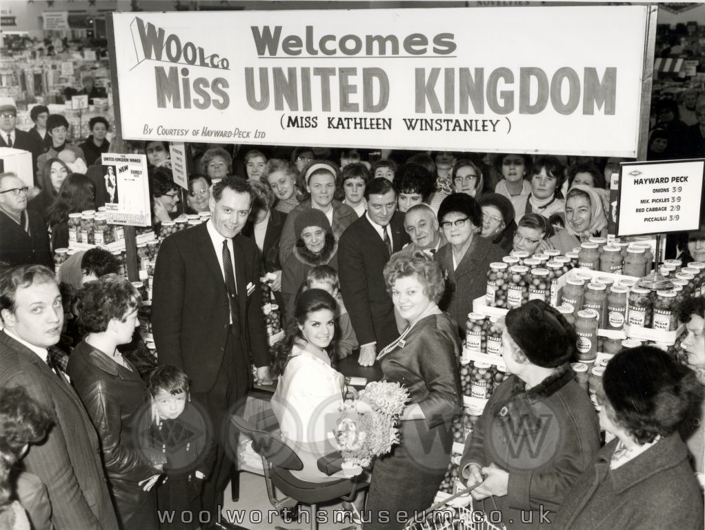 The indignities of being a beauty queen in the 1960s are plain to see as Miss Kathleen Winstanley (who had been described by Pathé News as "The lucky lass was Miss Wigan ... with the following vital statistics - 38, 23, 36 - just perfect!"). Her celebrity appearance was sponsored by Haywards, the makers of Pickled Onions and Piccalilly!