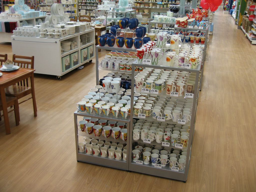 Glass shelving units stacked full with enough china mugs to feed the 5,000 in an out-of-town Woolworths store in 2005