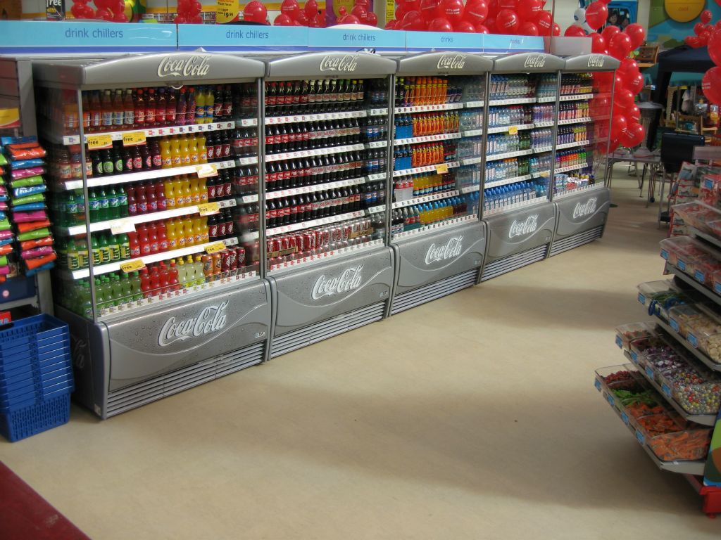 A long line of fridges, crammed with coca cola and other popular favourites in an out-of-town Woolworths in 2005