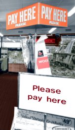 "Please pay here" a new sign that appeared in over 1,000 British Woolworths stores as they converted to self-service between 1970 and 1976