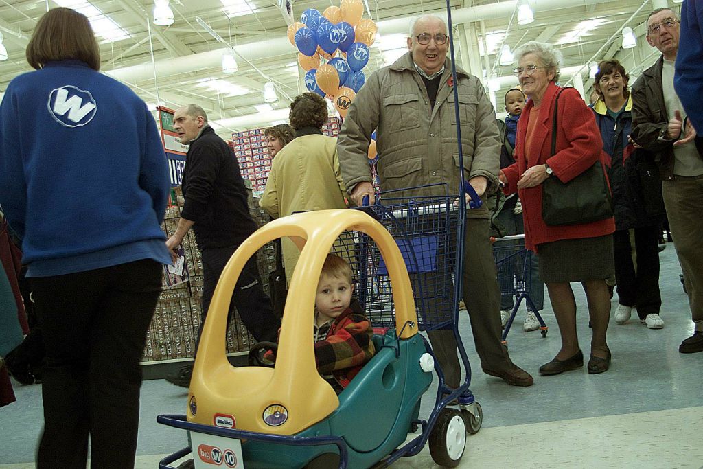 A child races towards the toy department in a Little Tikes buggy