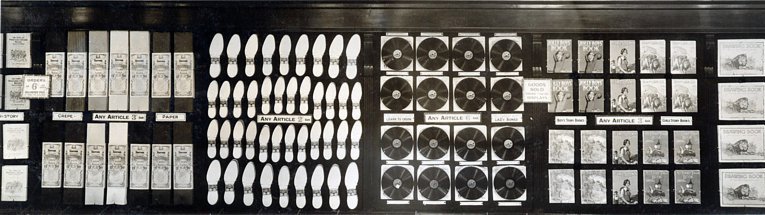 Gramophone Records on display in an F. W. Woolworth store in the 1930s.  The wall feature was for display only, with a stack of records on a counter below (out of shot).  The sign on the record display reads "Learn to croon for 6D"