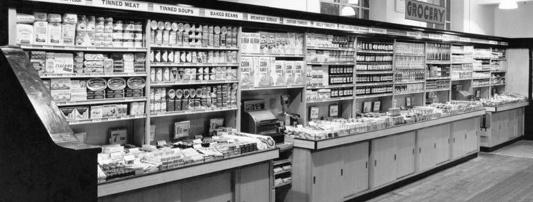 An elegant wall display of groceries in 1951. Customers were invited to serve themselves and take their purchases to the till in the middle of the display.  Not quite self-service but revolutionary at the time nonetheless.