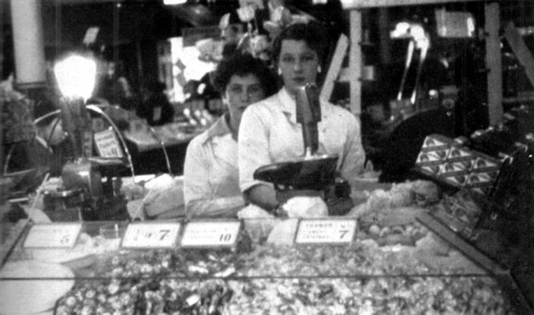 Colleagues serve on the pic'n'mix sweet counter in an F. W. Woolworth store in the 1950s