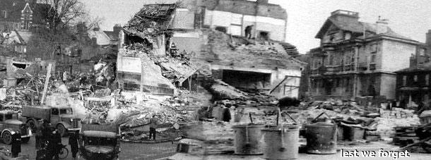 The devastation following the New Cross explosion.  Remember the heroes who dug with their bare hands in search for survivors.   (Note that the ornate Deptford Town Hall, which is still standing today, (and is now part of Goldsmiths College, University of London,) is clearly visible to the right of the picture above the words "lest we forget".   Click for greater detail in a new window.