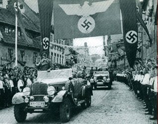 Adolf Hitler makes a "triumphal" entry into Asch, in the process liberating Fleissen from 290 years of tolerance and freedom, for the "safety and security" of oppression and fear.